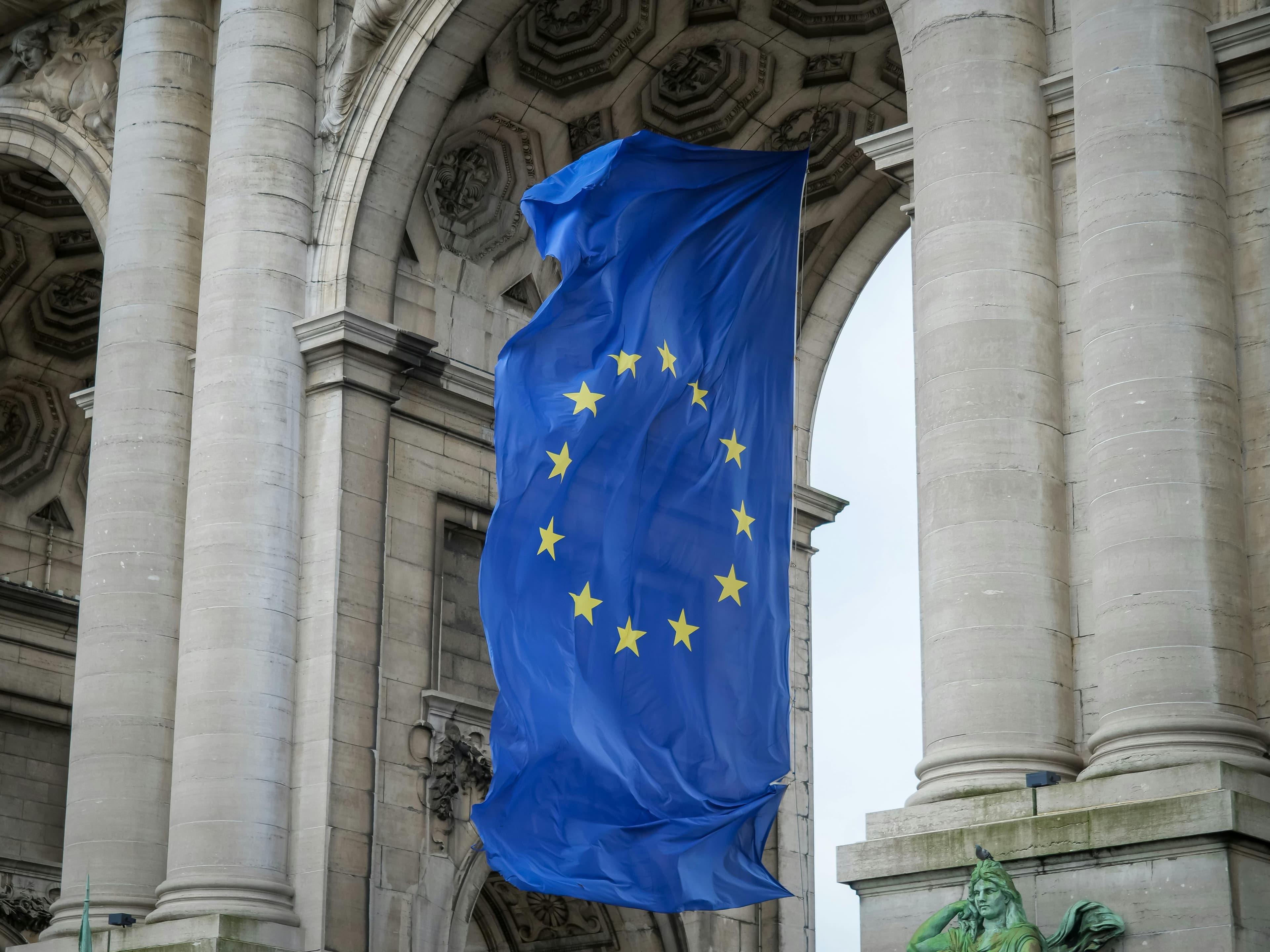 Europese vlag wappert voor een monumentaal gebouw