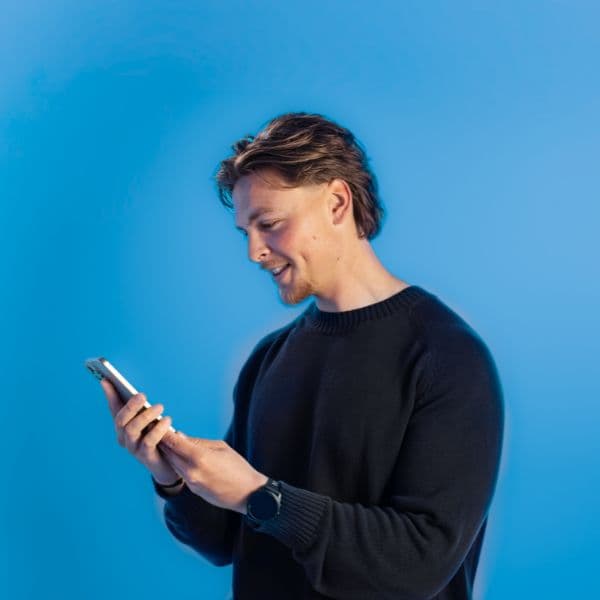 Adam kijkt op mobiel.