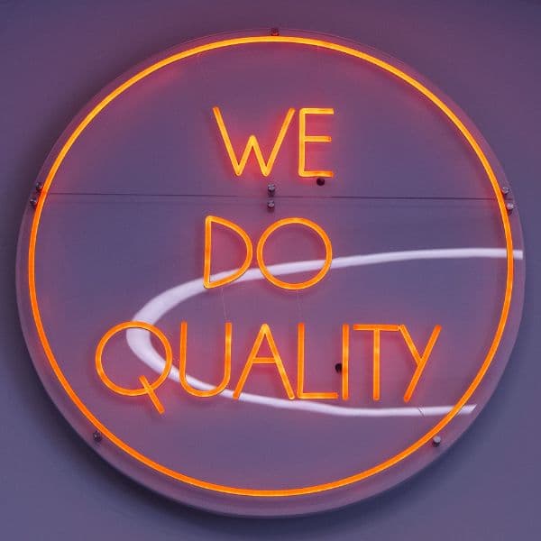 Neonbord met de tekst We do quality aan de kantoormuur